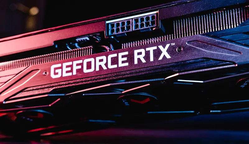 Carte graphique Nvidia GeForce RTX puissante et optimisée pour le montage vidéo, montrant des ventilateurs de refroidissement et des ports de sortie divers.