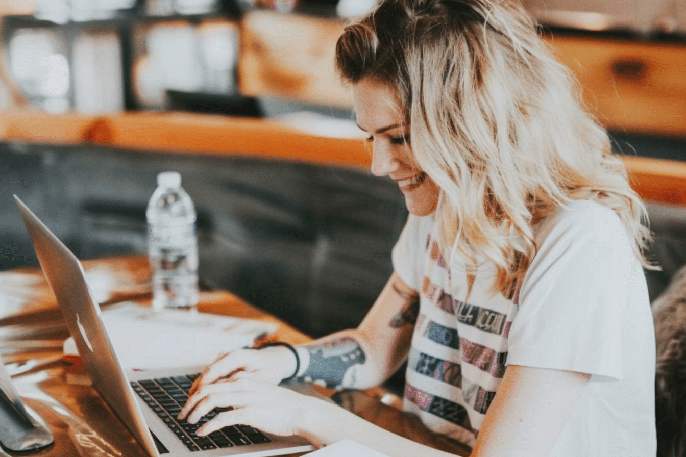 Femme souriante travaillant sur un ordinateur portable.